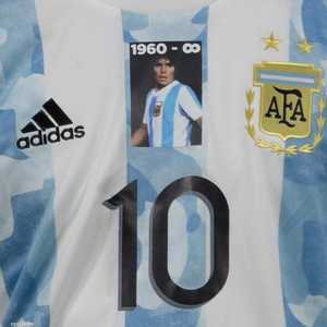 ميسي يرتدي قميصا وعليه صورة مارادونا