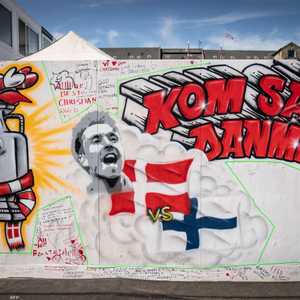 لوحة جدارية عليها صورة إريكسن تقول "هيا، الدنمارك"