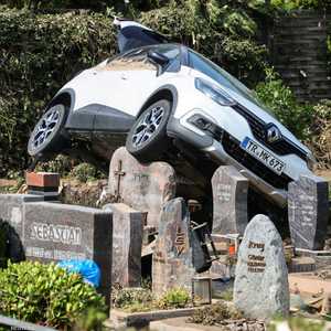 مركبة تستقر فوق إحدى المقابر بعد الأمطار الغزيرة