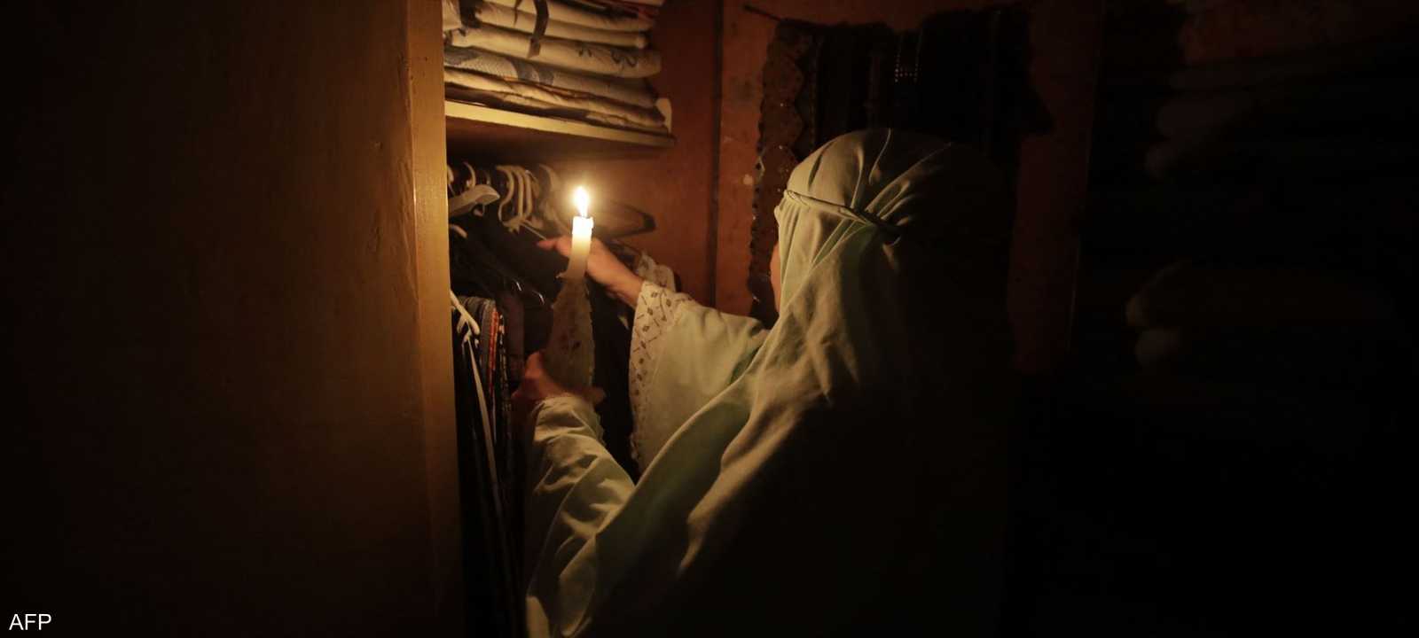 سيدة لبنانية تستخدم الشموع لتدبير أمورها المنزلية