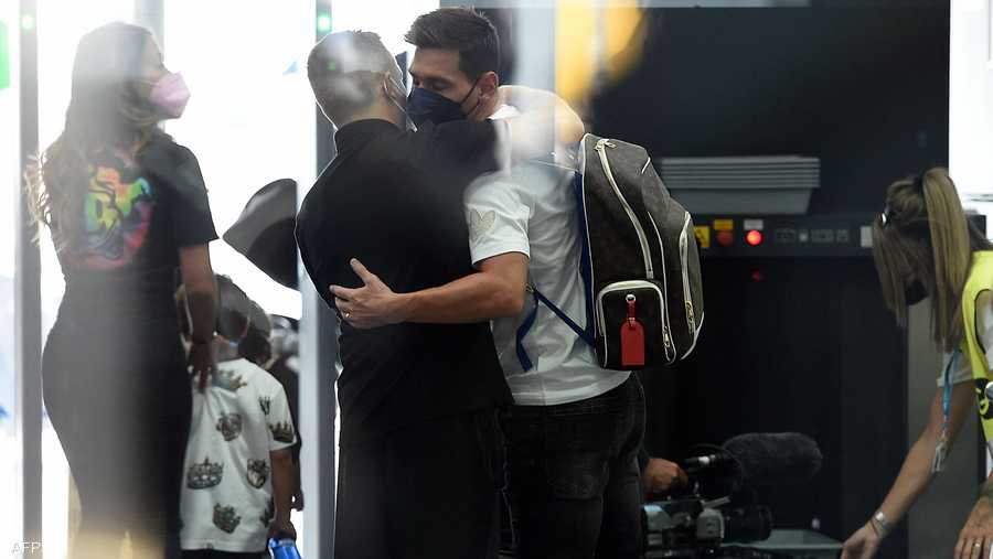 ميسي يعانق شخصا في مطار برشلونة