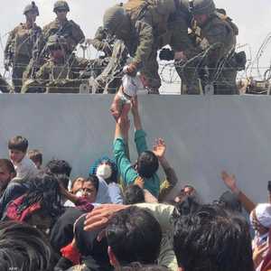 جندي أميركي ينتشل رضيعا فوق سياج مطار كابل خلال عملية إجلاء