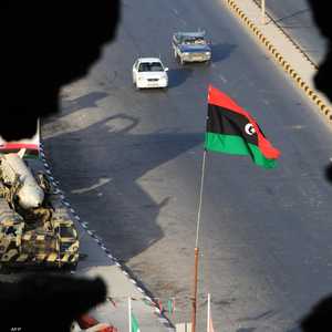 العلم الليبي يطل من خلال حائط مدمر (أرشيفية)