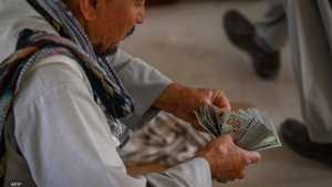 أرشيفية.. أفغاني يقوم بعد حزمة من الدولارات