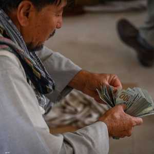 أرشيفية.. أفغاني يقوم بعد حزمة من الدولارات