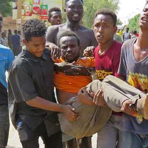 شبان يسعفون أحد المصابين في الاحتجاجات السودانية بالخرطوم.