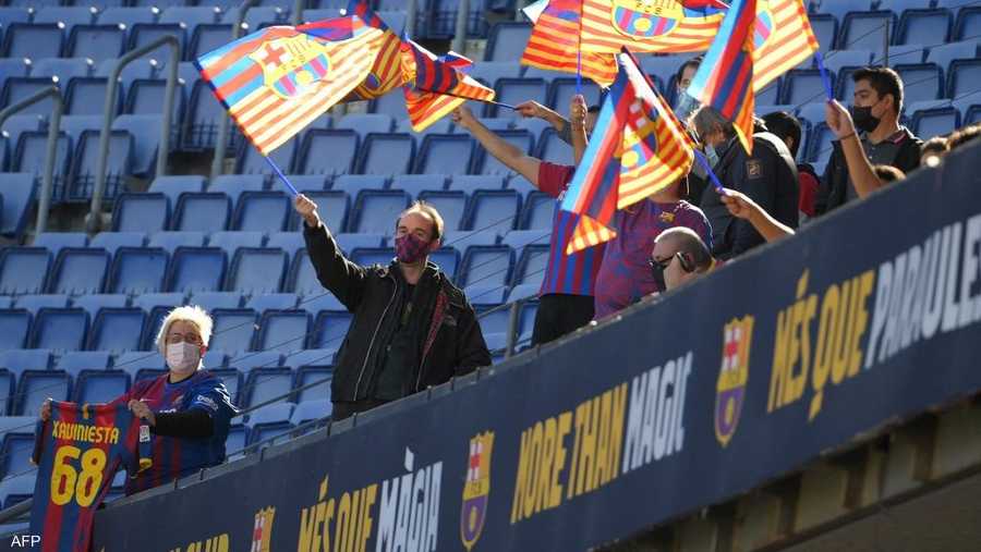 لوح تشافي للجماهير بعد دخوله إلى أرض الملعب برفقة رئيس برشلونة، خوان لابورتا.