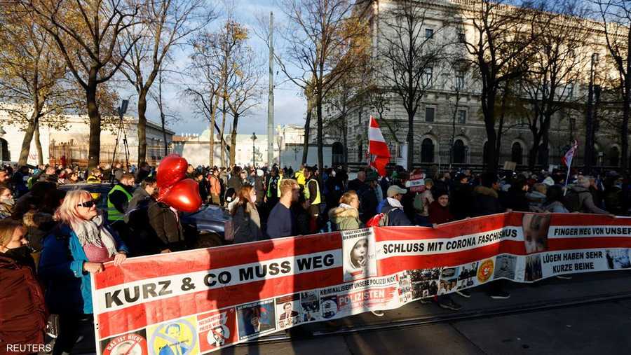 رفع الحشد بتظاهرة قرب مقر المستشارية في فيينا، لافتات تندد بـ"دكتاتورية كورونا" أو كتب عليها "لا لتقسيم المجتمع".