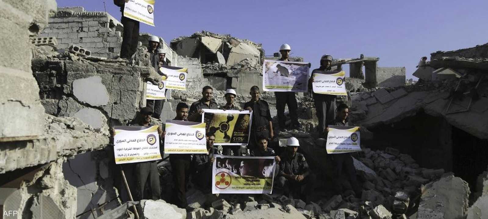 أفراد من أصحاب الخوذ البيضاء بموقع قصف بالكيماوي قرب دمشق.