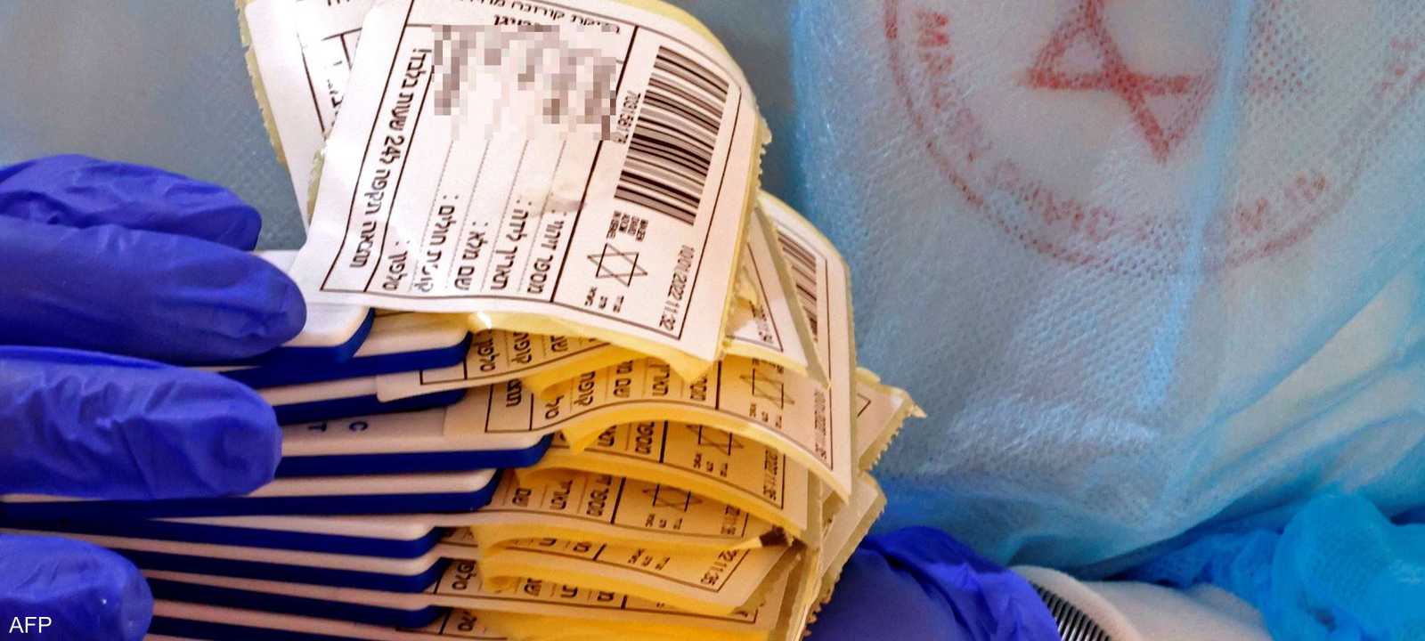 ممرضة تحمل عينات لفحوصات كورونا