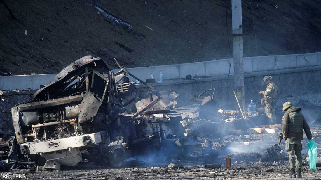 جنديان أوكرانيان يعاينان مركبة دمرت أثناء العملية الروسية