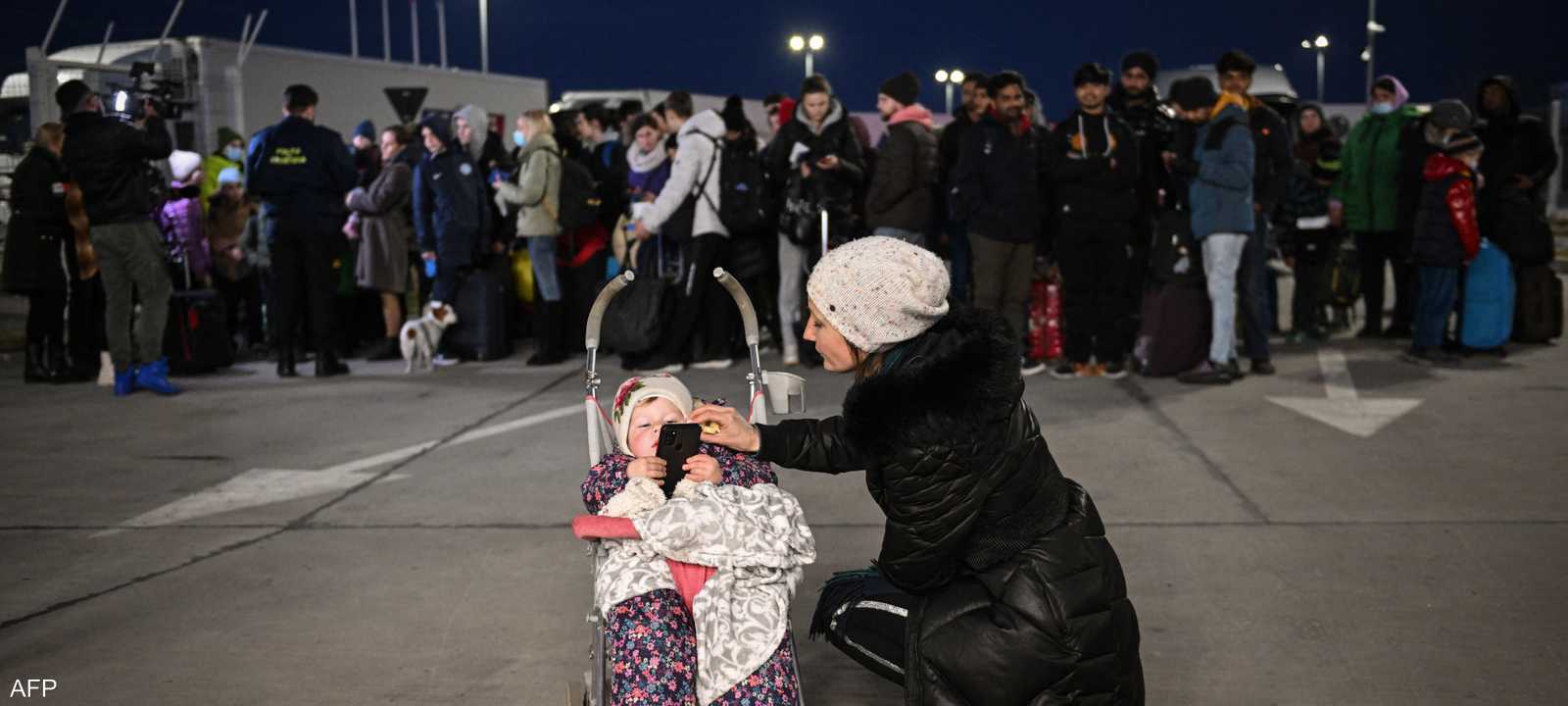 مواطنون أوكران ينتظرون دورهما على الحدود مع رومانيا