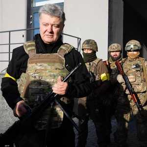 الرئيس الأوكراني السابق بيترو بوروشنكو حاملا الكلاشنكوف