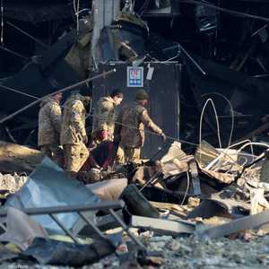 جنود أوكرانيون ينقلون جثة في موقع قصفته روسيا في كييف.