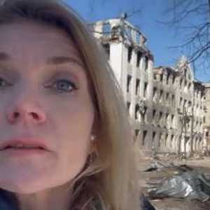 ماريا في شوارع خاركيف وفي الخلفية مبان دمرتها الحرب.