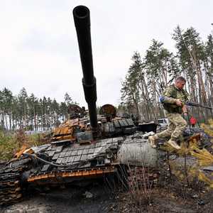 جندي أوكراني يقفز عن دبابة روسية مدمرة قرب كييف.