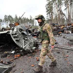 جندي روسي بجانب دبابة روسية محطمة