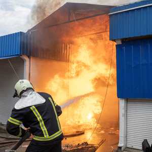 عمال الإطفاء يحاولون السيطرة على النيران الناجمة عن القصف