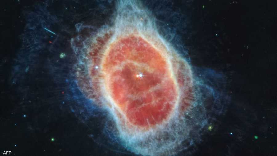 الغبار حول نجم قزم أبيض ساخن، تظهر على اليسار باللون الأحمر، في مركز السديم الدائري الجنوبي.