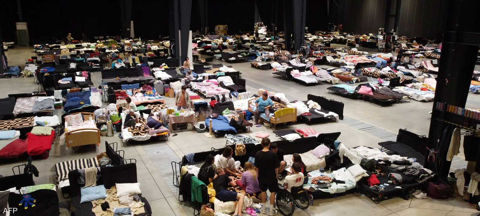 عشرات اللاجئين بأحد مراكز الإيواء في وارسو