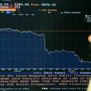 رجل يراقب شاشة تعرض مؤشر فوتسي100 الخاص ببورصة لندن