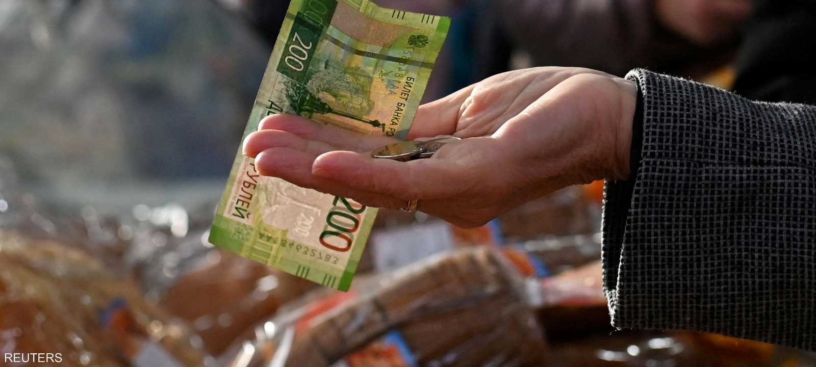 دفع عملات ورقية من الروبل الروسي في سوق في أومسك