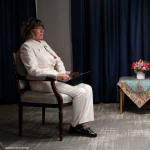 صورة لأمانبور أمام كرسي كان من المفترض أن يجلس عليه رئيسي