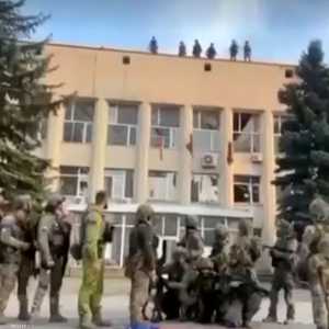 جنود أوكرانيون يقومون برمي العلم الروسي من على مبنى حكومي