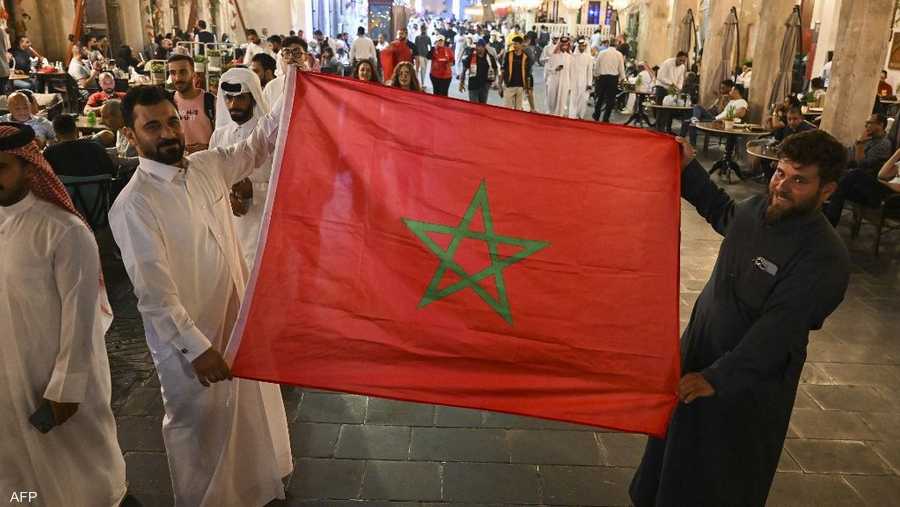 مشجعون في الدوحة يرفعون العلم المغربي
