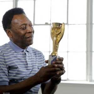 بيليه يحمل كأس العالم الذي فاز فيه عام 1958