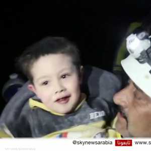 طفل سوري يبتسم بعد انتشاله من تحت الأنقاض