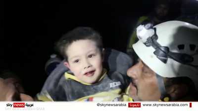 طفل سوري يبتسم ويلعب مع منقذيه بعد انتشاله من تحت الأنقاض