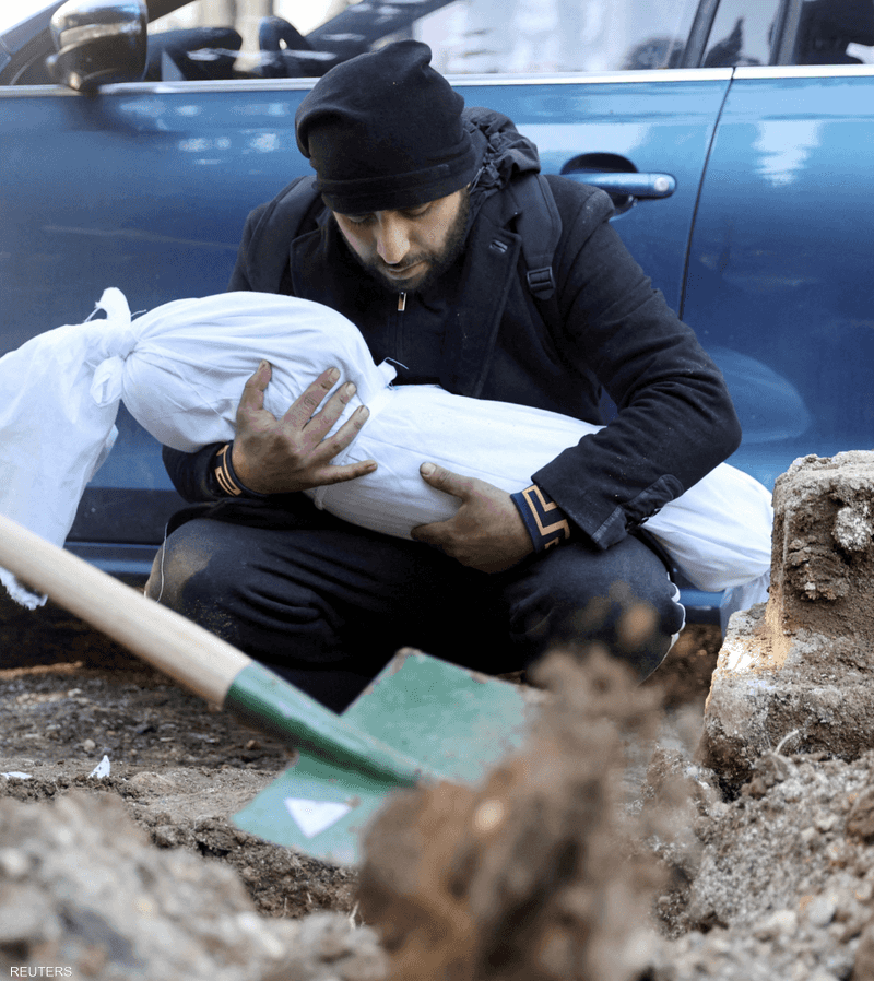 شخص تركي يقوم بدفن ابنته من ضحايا الزلزال في هاتاي