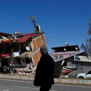 رجل يقف أمام منزل انهار بفعل الزلزال المدمر في كهرمان مرعش.