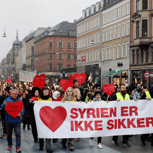 متظاهرون في شوارع الدنمارك ولافتة تقول: "سوريا ليست آمنة"