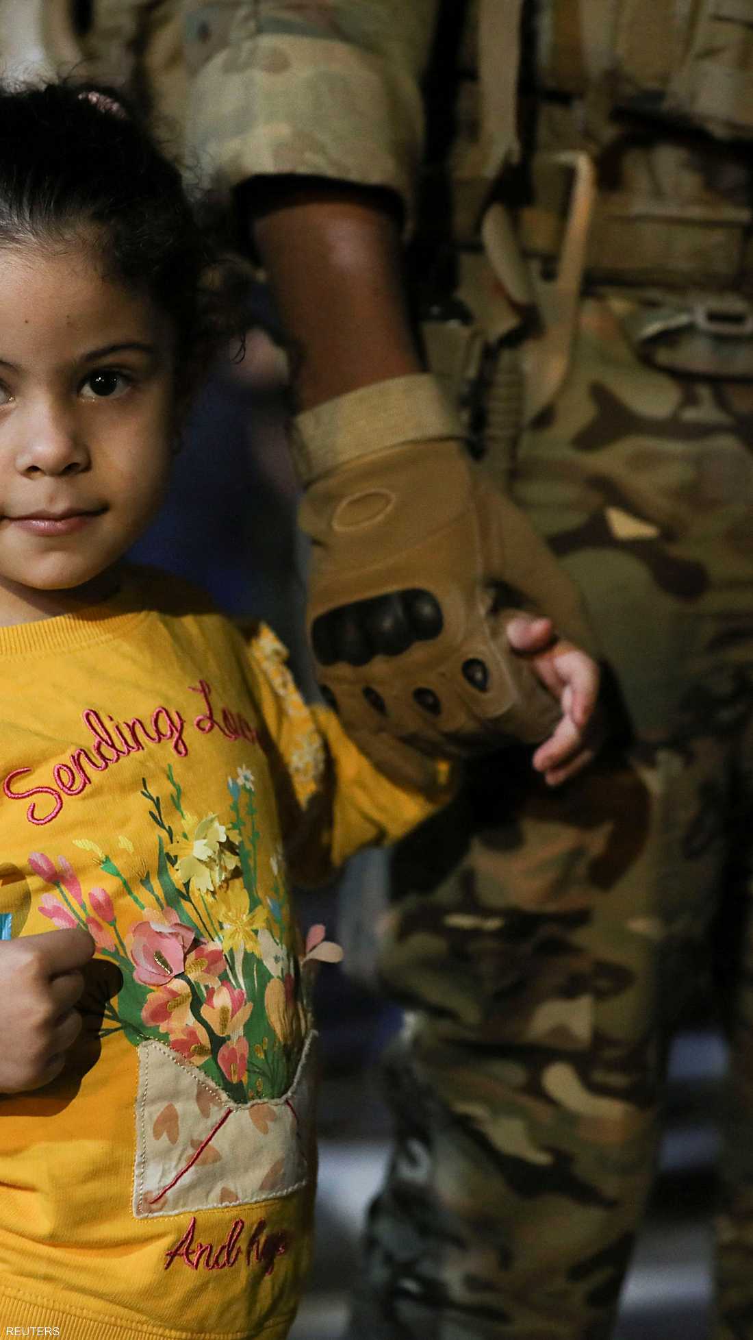جندي أردني يمسك بيد طفلة من عائلات القادمين
