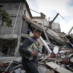 طفل فلسطيني يحمل ما تم إنقاذه من منزله المدمر في غزة