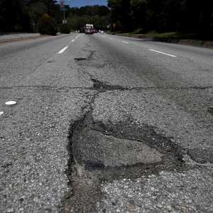 الرجل قرر إصلاح الحفرة بعد فشله بلفت نظر السلطات - أرشيفية