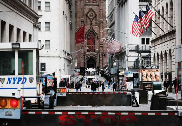 اقتصاد أميركا، اشخاص يسيرون بجوار بورصة نيويورك - وول ستريت