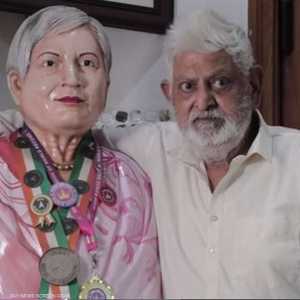 الرجل إلى جانب تمثال زوجته