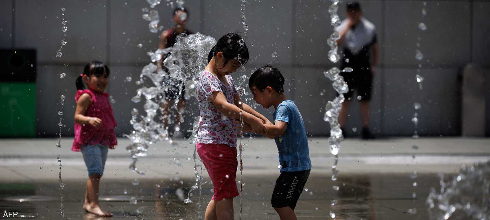 أطفال يهربون من الحر إلى النوافير في هونغ كونغ.