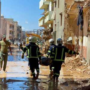 عناصر إنقاذ ينتشلون جثة في درنة.