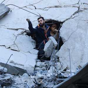 رجل وسط الركام بحثا عن ناجين من القصف