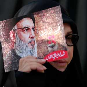 سيدة لبنانية تحمل صورة نصر الله