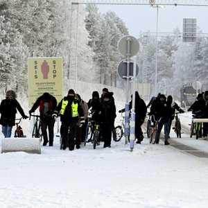 مهاجرون يسيرون عند المعبر الحدودي بين فنلندا وروسيا
