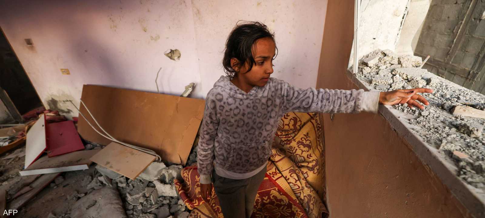 فتاة فلسطينية تعاين منزل دمرته ضربات إسرائيلية الاثنين