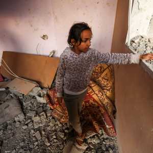 فتاة فلسطينية تعاين منزل دمرته ضربات إسرائيلية الاثنين