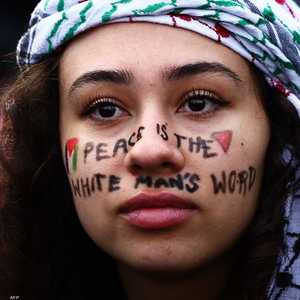 عبارة "السلام يفرضه الرجال البيض" على وجه محتجة في لندن