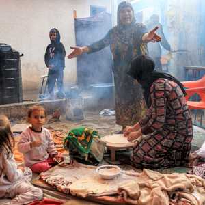 أم تعد الخبز التقليدي لإطعام صغارها في غزة