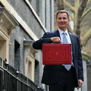 وزير الخزانة البريطاني يحمل حقيبة الميزانية الحمراء الشهيرة